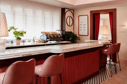 a bar with chairs and a counter in a room at The Hoxton, Florence in Florence