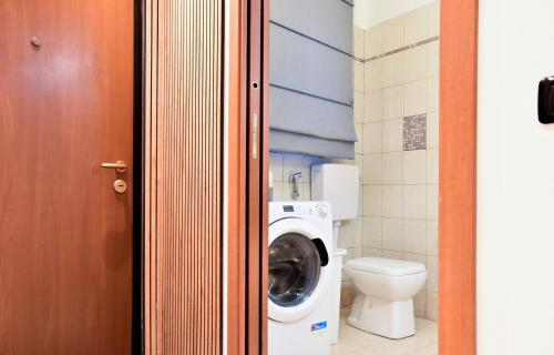 a bathroom with a washing machine and a toilet at Milano Malpensa AirHome in Somma Lombardo