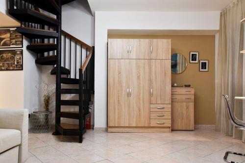 a living room with a staircase and a wooden cabinet at Milano Malpensa AirHome in Somma Lombardo