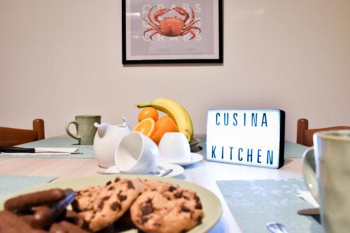 a table with a plate of cookies and a sign at Milano Malpensa AirHome in Somma Lombardo