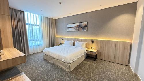 a hotel room with a bed and a large window at فندق آرام النسيم in Ash Shishah