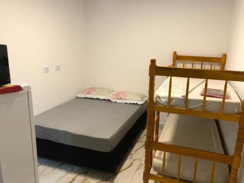 a bedroom with two bunk beds and a ladder at kitinet da familia in Matinhos