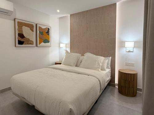 a bedroom with a large bed with white sheets and pillows at Villa Tiffany in Puerto del Carmen