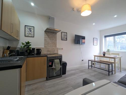a kitchen and living room with a stove and a table at Modern Apartment Near Manchester City Centre in Manchester