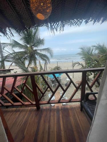 a balcony with a view of the beach and the ocean at Puerto Manglar Hostal in Guachaca