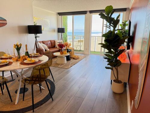 a living room with a table and a couch at Oceanfront 2 BR w Pool & Parking 234 in Hermosa Beach