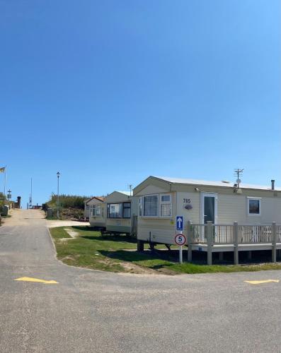 eine Reihe von Mobilheimen am Straßenrand in der Unterkunft Promenade park 8 Berth caravan next to the beach entrance, WIFI included in Ingoldmells