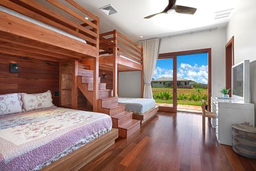 a bedroom with two bunk beds and a large window at Private Luxury 6-bedroom Villa in Kukuiula, Panoramic Ocean View, Heated infinity pool, SPA, Sleep up to 22 in Koloa