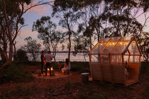 Un gruppo di persone in piedi accanto a una piccola casa di Numie - Freycinet Peninsula - Glamping - Heated - Waterfront a Coles Bay