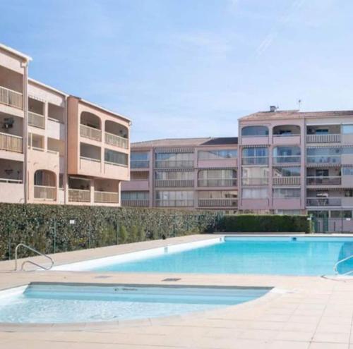 une piscine vide en face d'un bâtiment dans l'établissement Charmant 2P entièrement rénové , Piscine , 1 km de la plage, à Sainte-Maxime