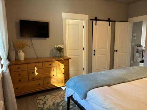 a bedroom with a bed and a dresser with a television at Large Flagstaff Home with Guest House in Flagstaff