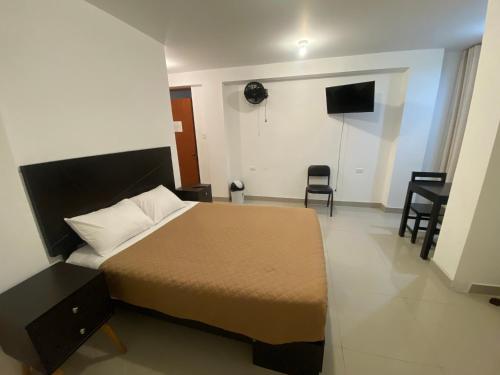 a bedroom with a bed and chairs in a room at Hotel Munay in Paracas