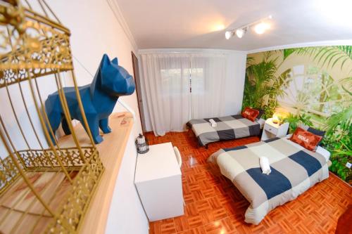 a bedroom with two beds and a blue dog statue at Live Oporto Rooms in Porto
