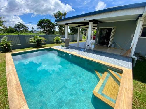 a swimming pool in the yard of a house at Villa Ahava in Pacific Harbour