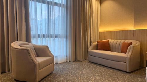 a room with two chairs and a couch and a window at فندق آرام النسيم in Ash Shishah