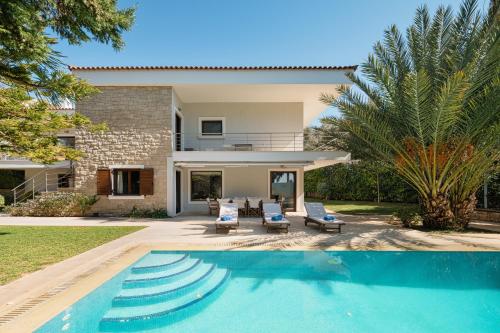 a villa with a swimming pool and a house at Villa Saronida in Saronida