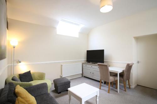 a living room with a couch a table and a tv at Newton House Hotel in Alstonfield