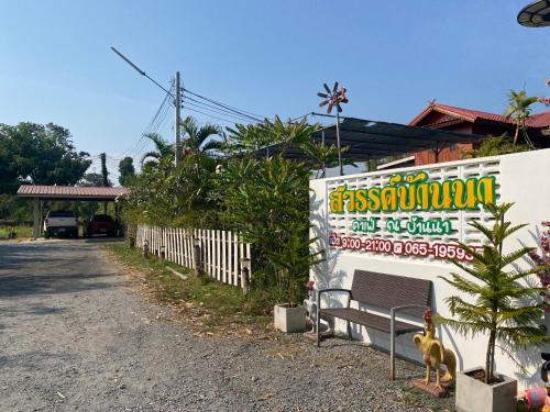 a dog sitting on a bench next to a fence at สวรรค์บ้านนา คาเฟ่ ณ บ้านนา in Pakha