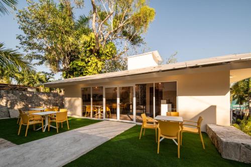 an outdoor dining area of a house with chairs and tables at Casa Aakal Lagoon Front in Bacalar