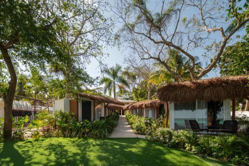 a resort with a lawn and trees and a pathway at Casa Aakal Lagoon Front in Bacalar