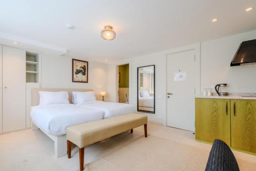 a white bedroom with a large bed and a table at Longchamps l Zamalek l Boutique Hotel with Breakfast in Cairo