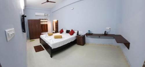 a bedroom with a bed and a desk in it at Veera Residency Gingee in Gingee