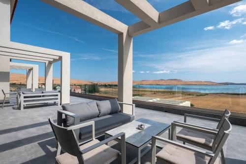 a living room with a couch and chairs on a patio at Aithra Lemnos in Thános
