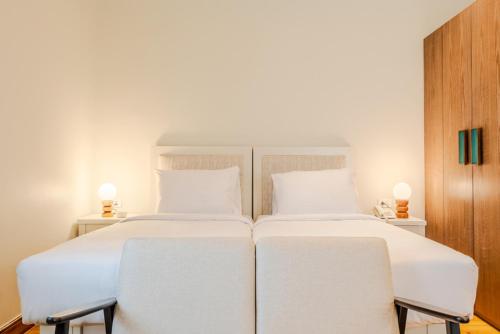 two white beds in a room with two chairs at Longchamps l Zamalek l Boutique Hotel with Breakfast in Cairo
