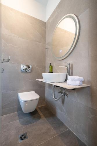 a bathroom with a sink and a toilet and a mirror at Aithra Lemnos in Thános