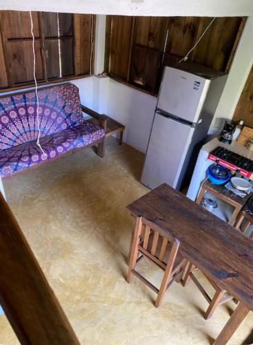 a kitchen with a couch and a table and a refrigerator at Casa Taolma in Zipolite