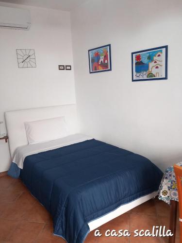 a bedroom with a bed with a blue blanket at A casa SCALILLA in Palermo