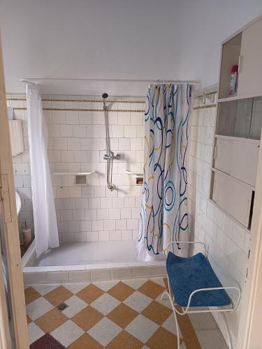 a bathroom with a shower and a blue chair at Casa rosa 2 in Mercedes