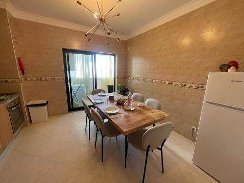 a dining room with a table and a refrigerator at Casa da Sofia by Rosado in Olhão