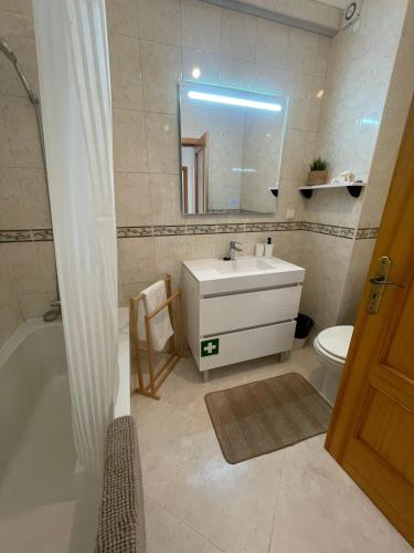 a bathroom with a sink and a tub and a toilet at Casa da Sofia by Rosado in Olhão