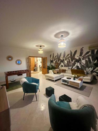 a living room with couches and chairs and a piano at Casa da Sofia by Rosado in Olhão