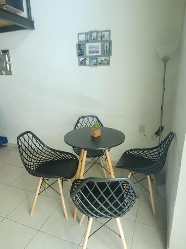 a table with three chairs and a table with a box on it at Loft en ciudad de Puebla in Puebla