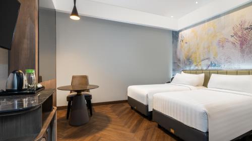 a hotel room with two beds and a table at Mercure Jayapura in Jayapura