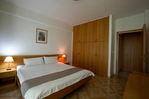 a bedroom with a large bed and a wooden cabinet at Adma Blue Screen in Jounieh