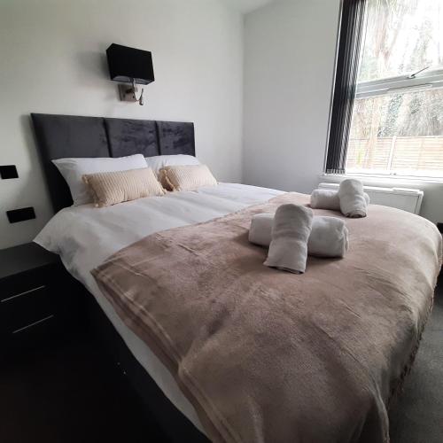 a large bed with two pillows on it in a bedroom at Stylish 3 bed 3 ensuites house with parking & garden in Reading