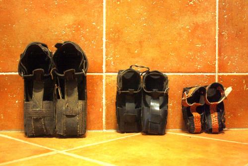a row of snow shoes on a tile wall at Hostal La Granja in Yunquera de Henares