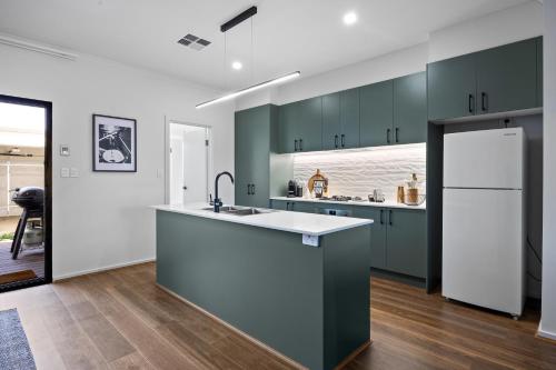 a kitchen with green cabinets and a white refrigerator at Olive Lane at Mount Barker Workspace, Wi-Fi in Mount Barker