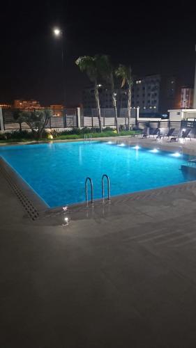 a large swimming pool at night with blue water at Appartement Haut standing et Piscine in Tangier