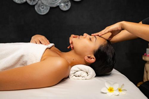 a woman laying on a bed getting a massage at Hilton Hotel Tahiti in Papeete