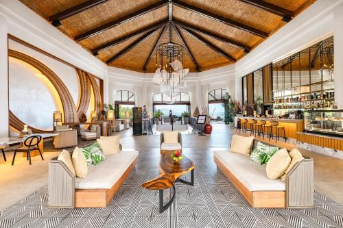 a large living room with couches and a bar at Hilton Hotel Tahiti in Papeete