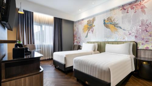 a hotel room with two beds and a tv at Mercure Jayapura in Jayapura