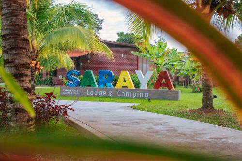 a sign for a house with a palm tree at Saraya Lodge & Camping in Iquitos