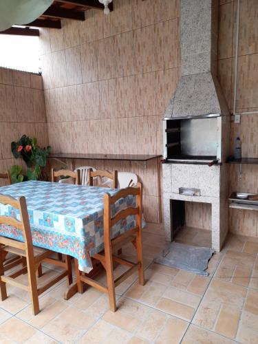 a dining room with a table and a oven at Martin de Sá - Casa da Olivia in Caraguatatuba
