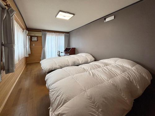 a bedroom with two white pillows on the wall at クリフ上熊本 in Kumamoto