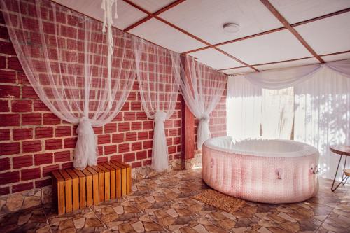 a bath tub in a room with a brick wall at Saraya Lodge & Camping in Iquitos