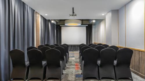 a conference room with black chairs and a screen at Mercure Jayapura in Jayapura